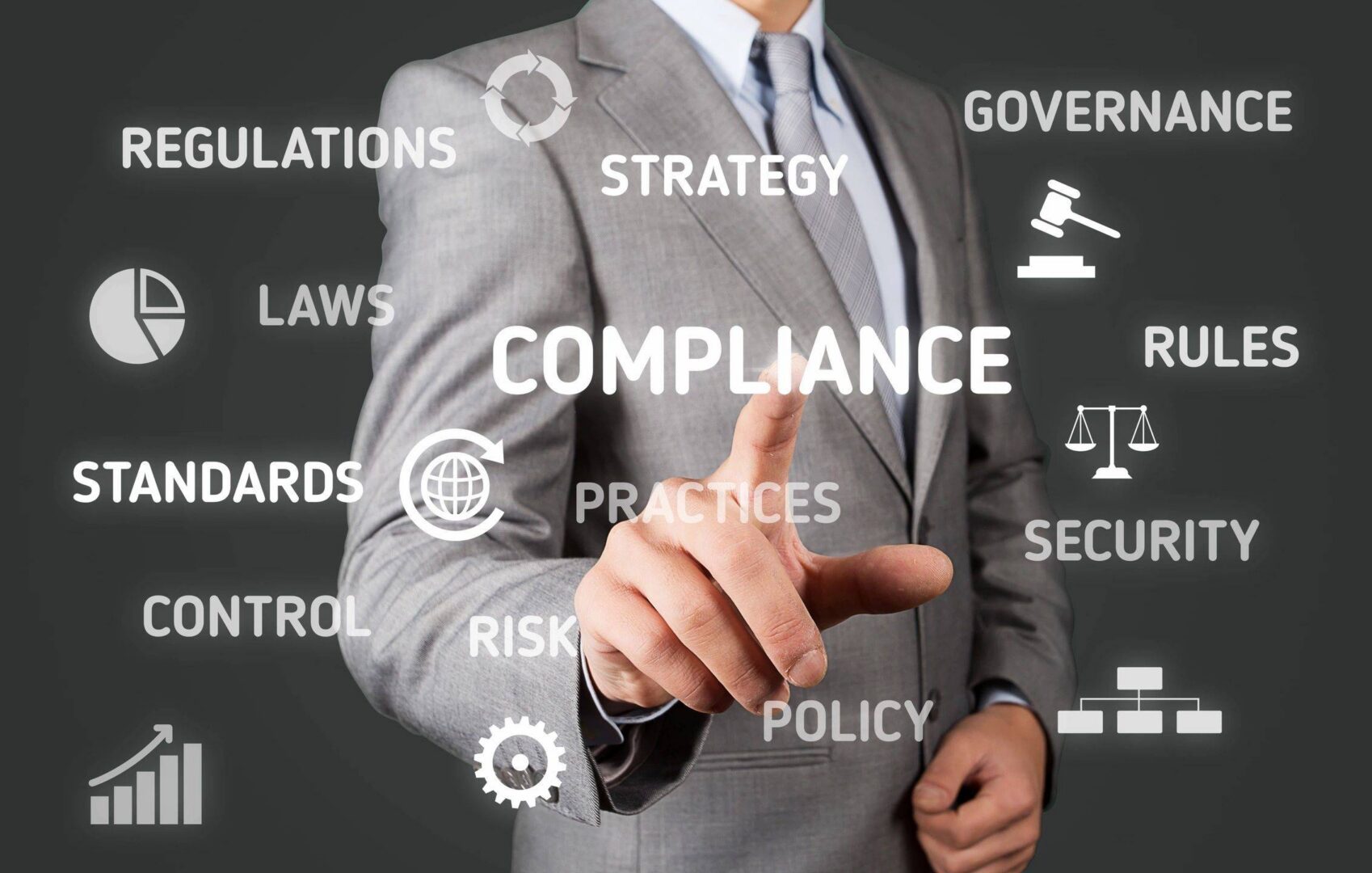 Businessman pointing at compliance and strategy concepts on transparent screen.