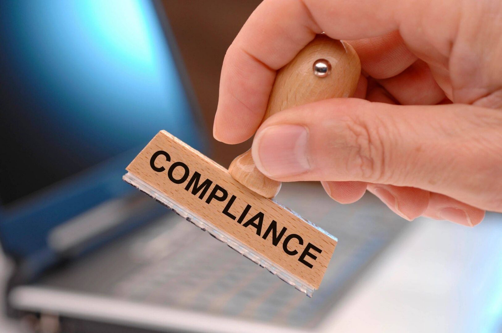 Hand stamping a compliance label on a document.